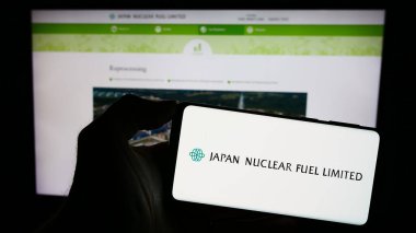 Stuttgart, Almanya - 11-08-2023: Japon enerji şirketi Japan Nuclear Fuel Ltd. (JNFL) 'nin logosunun bulunduğu cep telefonu sahibi. Telefon ekranına odaklan.