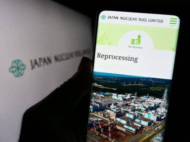 Stuttgart, Almanya - 11-08-2023: Japon enerji şirketi Japan Nuclear Fuel Ltd. (JNFL) 'nin logolu web sayfası ile akıllı telefon sahibi kişi. Telefon ekranının merkezine odaklan.