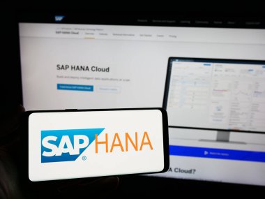 Stuttgart, Almanya - 11-08-2023: Veritabanı yönetim yazılımı SAP HANA 'nın logosunun bulunduğu cep telefonu şirketinin web sayfası önünde duruyor. Telefon ekranına odaklan.