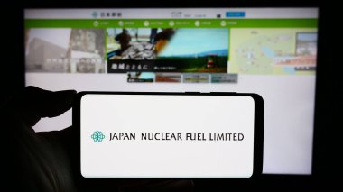 Stuttgart, Almanya - 11-08-2023: Japon enerji şirketi Japan Nuclear Fuel Ltd. (JNFL) 'nin logosuyla cep telefonu tutan kişi. Telefon ekranına odaklan.
