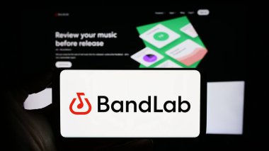 Stuttgart, Germany - 11-08-2023: Person holding cellphone with logo of Singaporean music company BandLab Technologies in front of business webpage. Focus on phone display. clipart