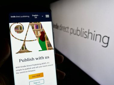 Stuttgart, Almanya - 11-09-2023: Logolu Amazon e-kitap platformu Kindle Direct Publishing (KDP) web sayfası ile akıllı telefon sahibi kişi. Telefon ekranının merkezine odaklan.