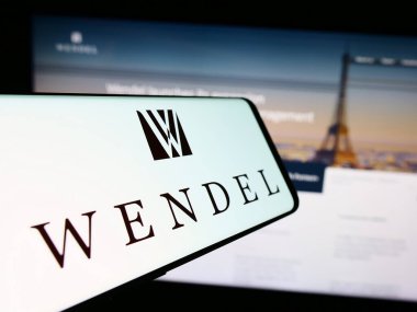 Stuttgart, Germany - 11-10-2023: Cellphone with logo of French investment company Wendel SE in front of business website. Focus on center of phone display. clipart