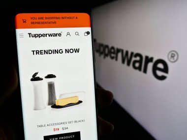 Stuttgart, Almanya - 11-10-2023: ABD 'li ev ürünü şirketi Tupperware Brands Corporation' ın logolu web sayfası ile akıllı telefon tutan kişi. Telefon ekranının merkezine odaklan.