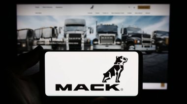 Stuttgart, Almanya - 11-10-2023: İnternet sitesinin önünde ABD 'li kamyon üreticisi Mack Trucks Inc.' in logosunu taşıyan kişi. Telefon ekranına odaklan.