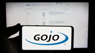 Stuttgart, Almanya - 11-10-2023: İnternet sitesi önünde ABD 'li tüketici malları şirketi Gojo Industries Inc.' in logosuna sahip kişi. Telefon ekranına odaklan.