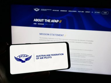Stuttgart, Almanya - 11-10-2023: Avustralya Hava Pilotları Federasyonu (AFAP) ortaklığı logosuna sahip akıllı telefon sahibi kişi web sitesi önünde. Telefon ekranına odaklan.