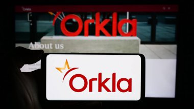Stuttgart, Almanya - 11-11-2023: Norveçli firma Orkla ASA 'nın logosunun bulunduğu akıllı telefonu web sitesinin önünde tutan kişi. Telefon ekranına odaklan.