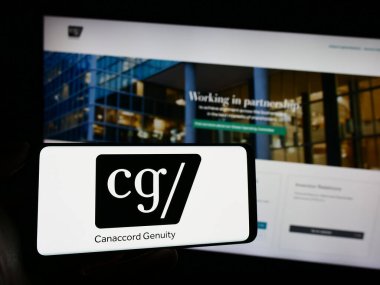 Stuttgart, Almanya - 11-11-2023: Kanadalı finans şirketi Canaccord Genuity Group Inc. 'in logosunun bulunduğu cep telefonu web sayfasının önünde duruyor. Telefon ekranına odaklan.