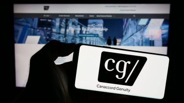 Stuttgart, Almanya - 11-11-2023: Kanadalı finans şirketi Canaccord Genuity Group Inc. 'in logosuyla cep telefonu tutan kişi web sayfasının önünde. Telefon ekranına odaklan.