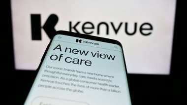 Stuttgart, Germany - 11-11-2023: Smartphone with website of US consumer health products company Kenvue Inc. in front of business logo. Focus on top-left of phone display. clipart