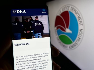Stuttgart, Almanya - 11-11-2023: Mühür önünde ABD Uyuşturucu Uygulama Dairesi (DEA) web sayfası bulunan kişi. Telefon ekranının merkezine odaklan.