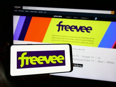Stuttgart, Almanya - 11-11-2023: Web sitesi önünde ABD 'li videolu yayın servisi Amazon Freevee' nin logosuna sahip kişi. Telefon ekranına odaklan.