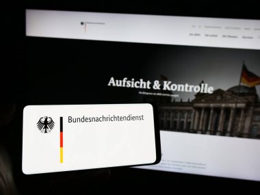 Stuttgart, Almanya - 11-11-2023: İnternet sayfası önünde Alman istihbarat ajansı Bundesnachrichtendienst 'in (BND) logosuyla cep telefonu tutan kişi. Telefon ekranına odaklan.