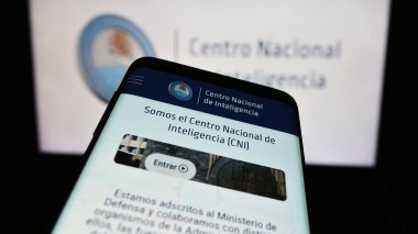 Stuttgart, Almanya - 11-12-2023: İstihbarat ajansı Centro Nacional de Inteligencia 'nın (CNI) internet sitesiyle birlikte logo önünde cep telefonu. Telefon ekranının sol üst kısmına odaklan.