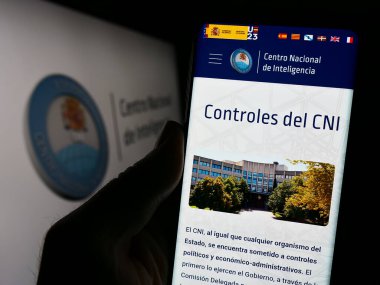 Stuttgart, Almanya - 11-12-2023: İstihbarat ajansı Centro Nacional de Inteligencia 'nın (CNI) logolu web sayfası ile akıllı telefon tutan kişi. Telefon ekranının merkezine odaklan.