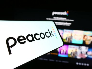 Stuttgart, Almanya - 11-14-2023: İnternet sitesi önünde Amerikan video yayın servisi şirketi Peacock TV LLC 'nin logosuna sahip cep telefonu. Telefon ekranının merkez soluna odaklan.