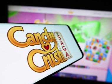 Stuttgart, Almanya - 11-14-2023: İnternet sitesinin önünde yer alan, fayansla eşleşen video oyunu Candy Crush Saga logosuna sahip cep telefonu. Telefon ekranının merkez soluna odaklan.