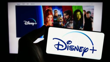 Stuttgart, Almanya - 11-14-2023: Web sitesi önünde ABD video-talep üzerine yayın servisi Disney Plus 'ın logosuna sahip kişi. Telefon ekranına odaklan.