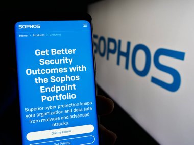 Stuttgart, Almanya - 11-15-2023: İngiliz güvenlik yazılım şirketi Sophos Group plc 'un logolu web sayfası ile cep telefonu tutan kişi. Telefon ekranının merkezine odaklan.