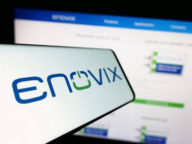 Stuttgart, Almanya - 09-25-2023: Amerikan batarya şirketi Enovix Corporation 'ın logosu ile birlikte cep telefonu iş sitesi önünde. Telefon ekranının merkez soluna odaklan.