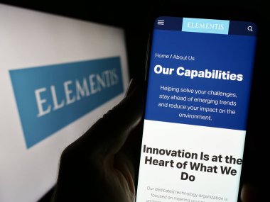 Stuttgart, Almanya - 09-25-2023: İngiliz özel kimya şirketi Elementis plc 'nin web sitesi ile logo önünde cep telefonu tutan kişi. Telefon ekranının merkezine odaklan.