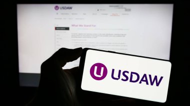 Stuttgart, Almanya - 09-27-2023: İnternet sayfası önünde üzerinde Dükkan Dağıtım ve Müttefik İşçiler Birliği (USDAW) logosu bulunan cep telefonu sahibi kişi. Telefon ekranına odaklan.