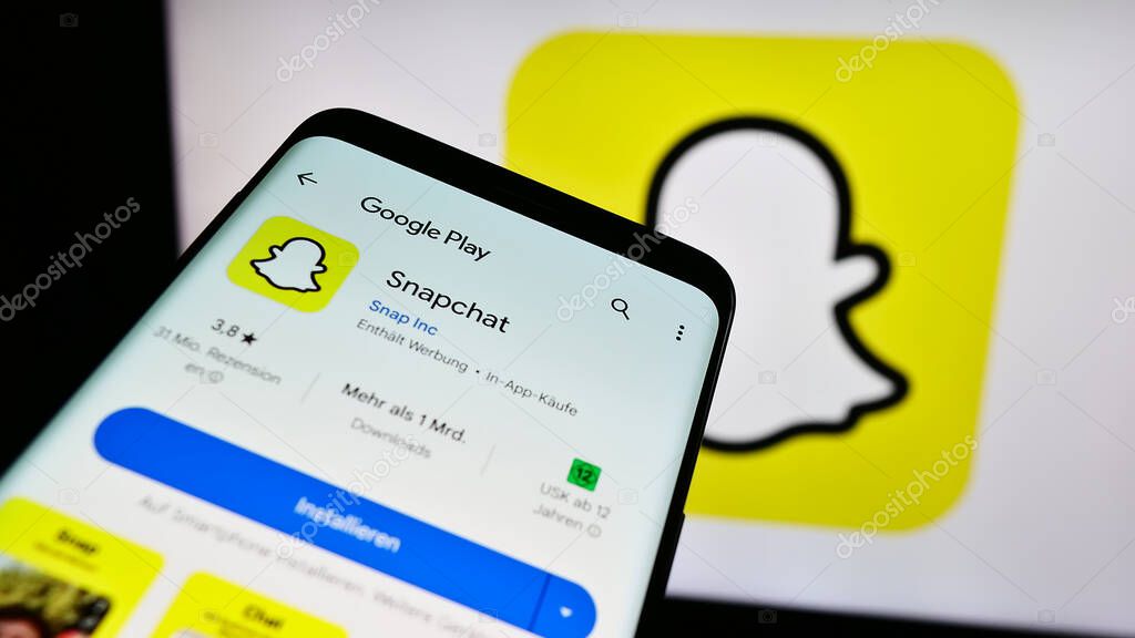 Stuttgart, Germany - 11-14-2023: Smartphone with website of US multimedia instant messaging app Snapchat in front of business logo. Focus on top-left of phone display.