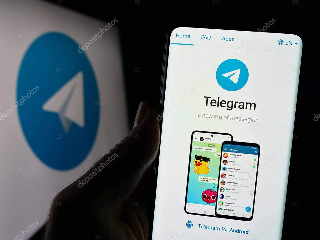 Stuttgart, Germany - 11-14-2023: Person holding smartphone with webpage of instant messaging service Telegram Messenger in front of logo. Focus on center of phone display.