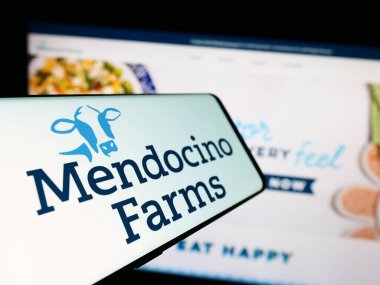 Stuttgart, Germany - 09-27-2023: Cellphone with logo of American fast casual restaurant chain Mendocino Farms in front of company website. Focus on center-left of phone display. clipart