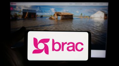 Stuttgart, Germany - 10-06-2023: Person holding smartphone with logo of international development organization BRAC in front of website. Focus on phone display. clipart