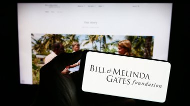 Stuttgart, Almanya - 10-06-2023: Web sayfası önünde üzerinde American Bill ve Melinda Gates Foundation (BMGF) logosu bulunan kişi. Telefon ekranına odaklan.