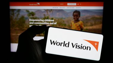 Stuttgart, Almanya - 10-06-2023: Dünya Vizyon Örgütü logosu olan cep telefonu web sayfası önünde. Telefon ekranına odaklan.