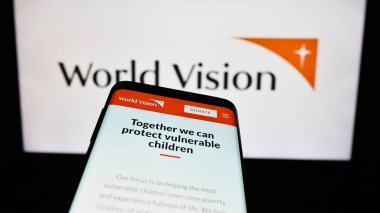 Stuttgart, Almanya - 10-06-2023: Uluslararası Dünya Vizyon Örgütü web sitesi logosu önünde cep telefonu. Telefon ekranının sol üst kısmına odaklan.