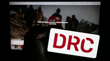 Stuttgart, Almanya - 10-08-2023: İnsani yardım örgütü Danimarka Mülteci Konseyi 'nin (DRC) logosunun bulunduğu cep telefonu web sayfası önünde duruyor. Telefon ekranına odaklan.