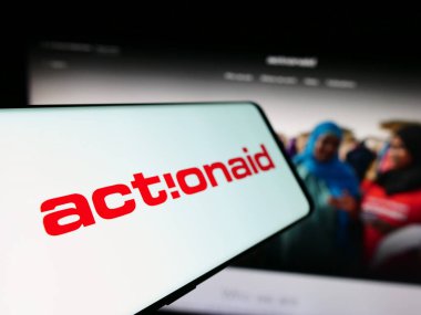 Stuttgart, Germany - 10-08-2023: Cellphone with logo of international charity organization ActionAid in front of website. Focus on left of phone display. clipart