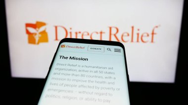 Stuttgart, Almanya - 10-08-2023: ABD insani yardım örgütünün web sitesiyle birlikte logo önünde cep telefonu. Telefon ekranının sol üst kısmına odaklan.
