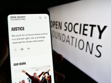 Stuttgart, Almanya - 10-09-2023: Logo önünde Açık Toplum Vakfının (OSF) web sitesi ile cep telefonu tutan kişi. Telefon ekranının merkezine odaklan.