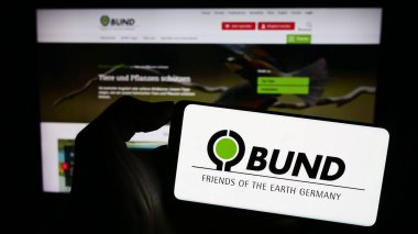 Stuttgart, Almanya - 10-10-2023: Bund kürkü Umwelt ve Naturschutz Deutschland E.V. logosu taşıyan kişi Web sayfasının önünde. Telefon ekranına odaklan.