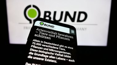 Stuttgart, Almanya - 10-10-2023: Bund fuer Umwelt und Naturschutz Deutschland 'ın logosuna sahip cep telefonu. İnternet sitesinin önünde. Telefon ekranına odaklan.