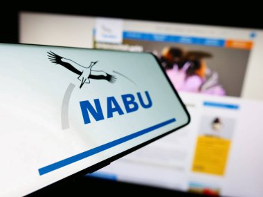 Stuttgart, Germany - 10-10-2023: Smartphone with logo of association Naturschutzbund Deutschland eV (NABU) in front of website. Focus on center-left of phone display. clipart