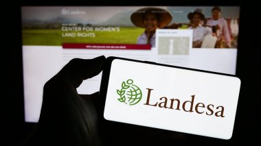 Stuttgart, Almanya - 10-10-2023: İnternet sayfası önünde üzerinde Landesa Kırsal Gelişim Enstitüsü logosu bulunan cep telefonu sahibi kişi. Telefon ekranına odaklan.