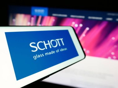 Stuttgart, Almanya - 10-13-2023: Alman cam imalat şirketi Schott AG 'nin logosuna sahip akıllı telefon iş sitesinin önünde. Telefon ekranının merkez soluna odaklan.