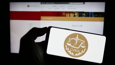 Stuttgart, Almanya - 10-16-2023: İnternet sayfası önünde AB kurumu Avrupa Adalet Divanı 'nın (AİHM) logosuyla cep telefonu tutan kişi. Telefon ekranına odaklan.