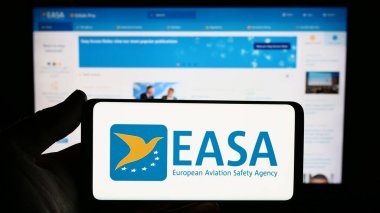 Stuttgart, Almanya - 10-17-2023: İnternet sitesi önünde Avrupa Birliği Havacılık Güvenliği Ajansı (EASA) logosu bulunan kişi. Telefon ekranına odaklan.