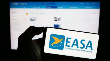 Stuttgart, Almanya - 10-17-2023: İnternet sayfası önünde Avrupa Birliği Havacılık Güvenliği Ajansı (EASA) logosu bulunan kişi. Telefon ekranına odaklan.
