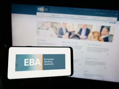 Stuttgart, Almanya - 10-20-2023: İnternet sitesi önünde AB kurumunun Avrupa Bankacılık Dairesi (EBA) logosuna sahip akıllı telefon sahibi kişi. Telefon ekranına odaklan.