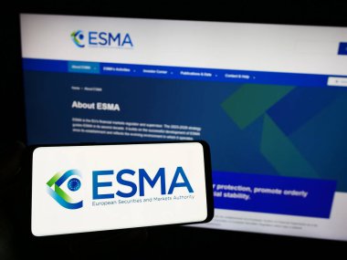 Stuttgart, Almanya - 10-20-2023: İnternet sitesi önünde üzerinde Avrupa Menkul Kıymetler ve Piyasa Dairesi (ESMA) logosu bulunan kişi. Telefon ekranına odaklan.