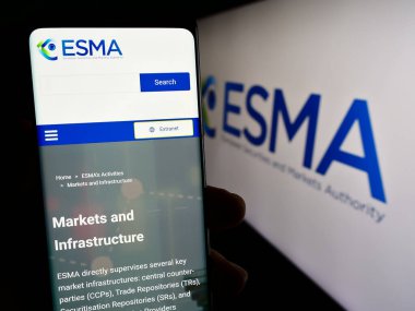 Stuttgart, Almanya - 10-20-2023: Logo önünde Avrupa Menkul Kıymetler ve Piyasalar Dairesi 'nin (ESMA) web sayfası bulunan cep telefonu sahibi. Telefon ekranının merkezine odaklan.