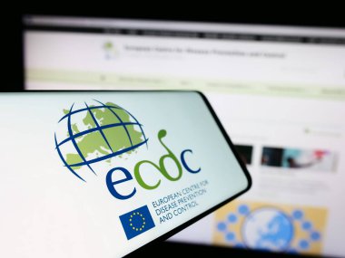 Stuttgart, Germany - 10-25-2023: Mobile phone with logo of European Centre for Disease Prevention and Control (ECDC) in front of website. Focus on center-left of phone display. clipart